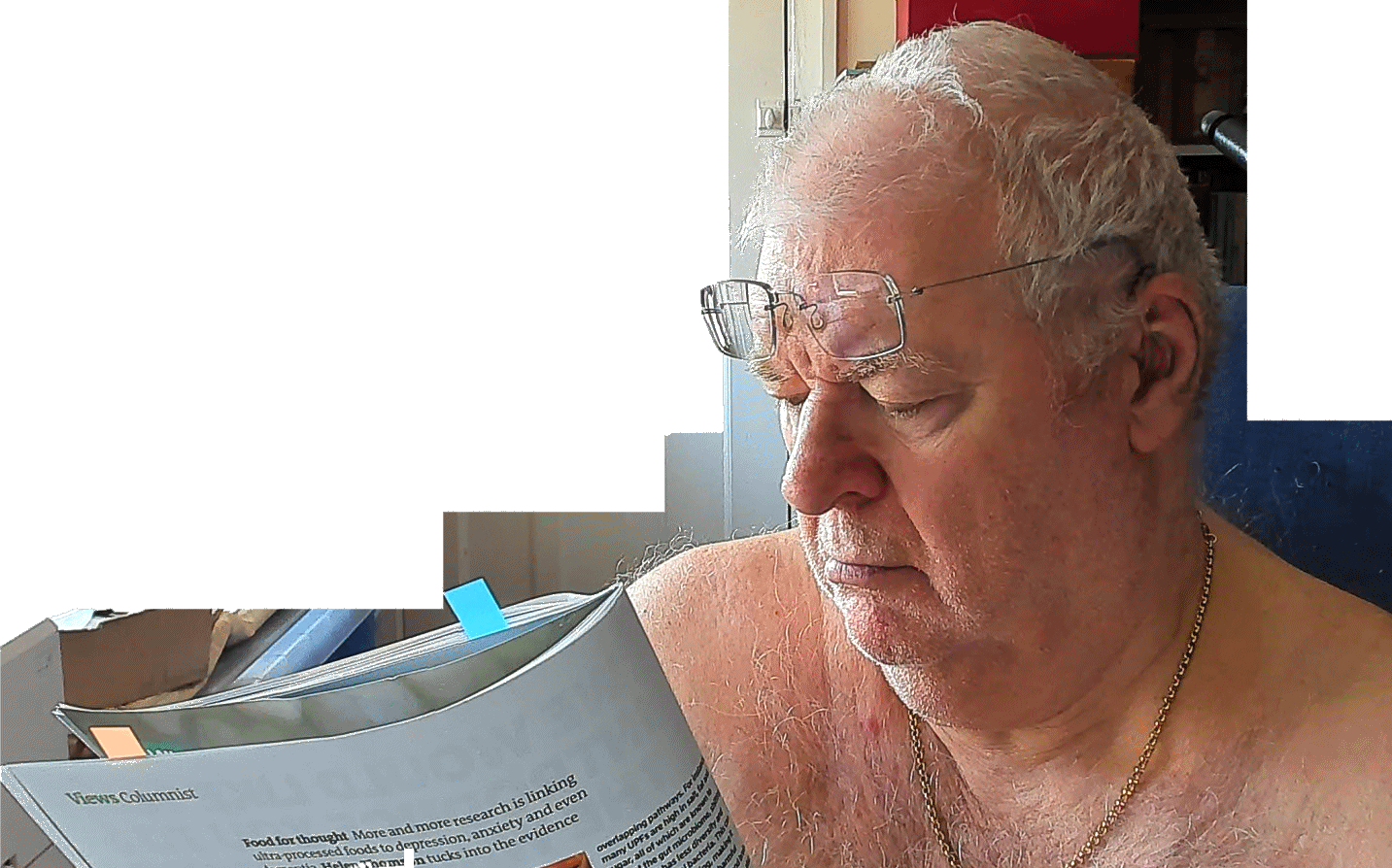 senior male without shirt reading a magazine